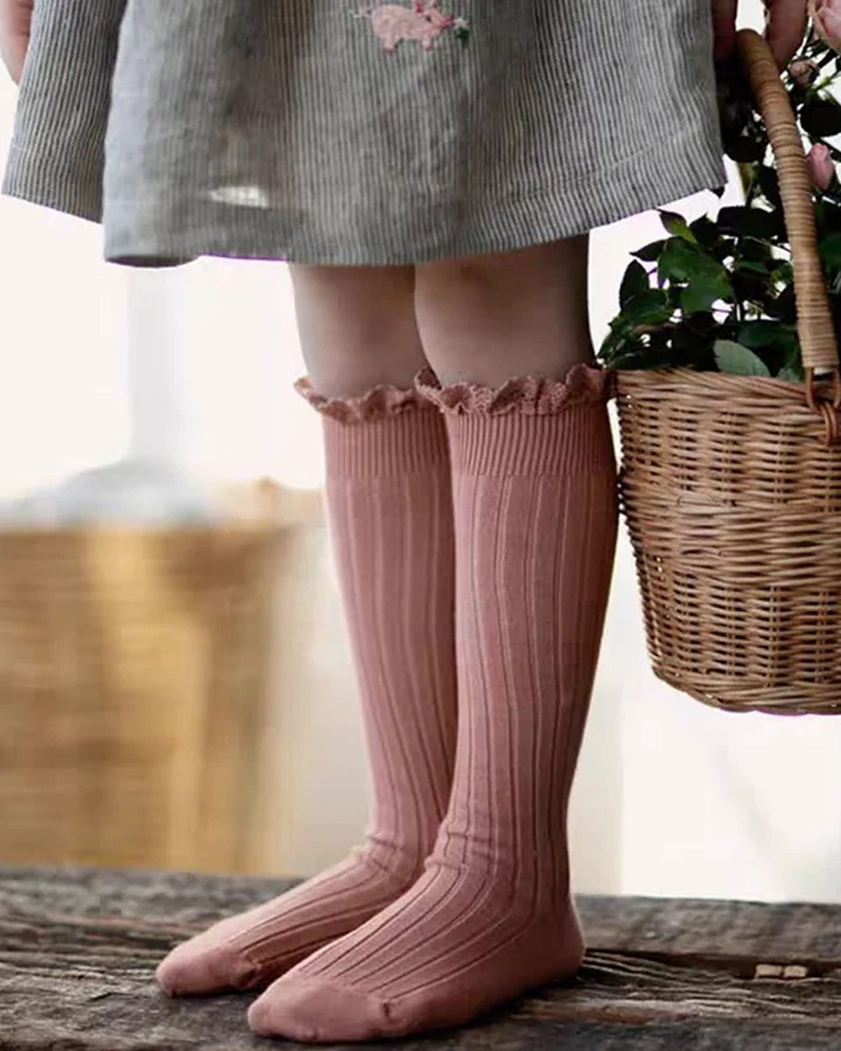 Child wearing pink ruffle knee-high socks