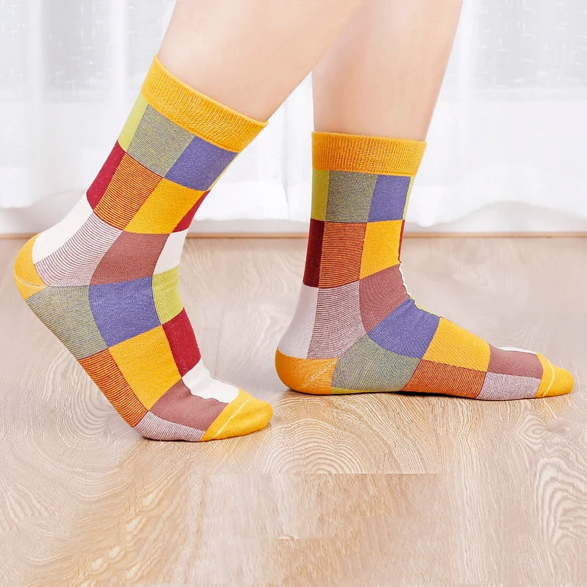 Feet in colourful patchwork socks on a wooden floor